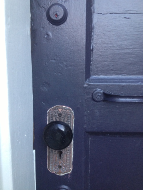 A vintage black ceramic knob now graces the restored doorplate